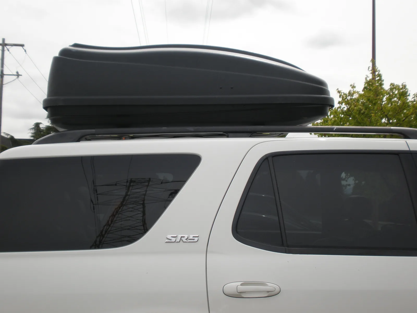 Coffre de toit installé sur un SUV avant un départ en vacances