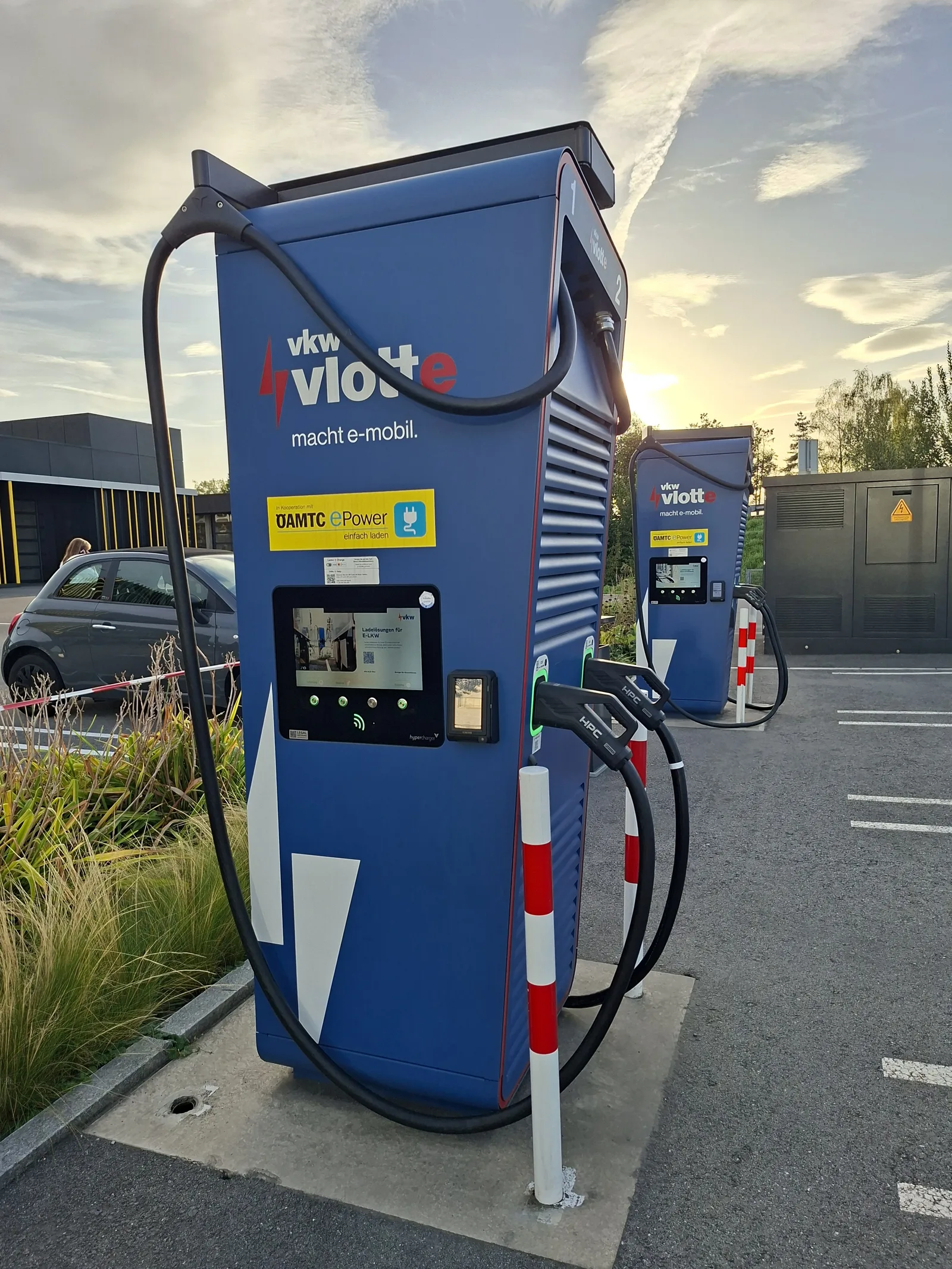 Voiture électrique branchée sur une borne de recharge publique, illustration du comparatif hybride ou électrique