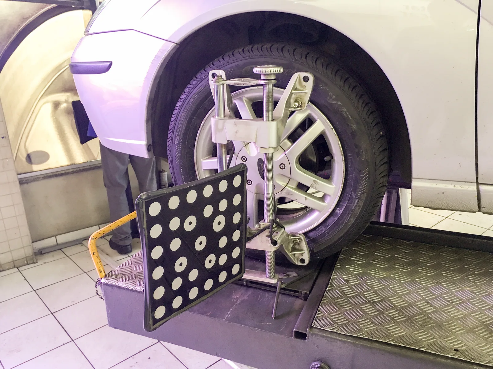 Dispositif de mesure laser fixé sur une roue avant lors d'un contrôle de parallélisme