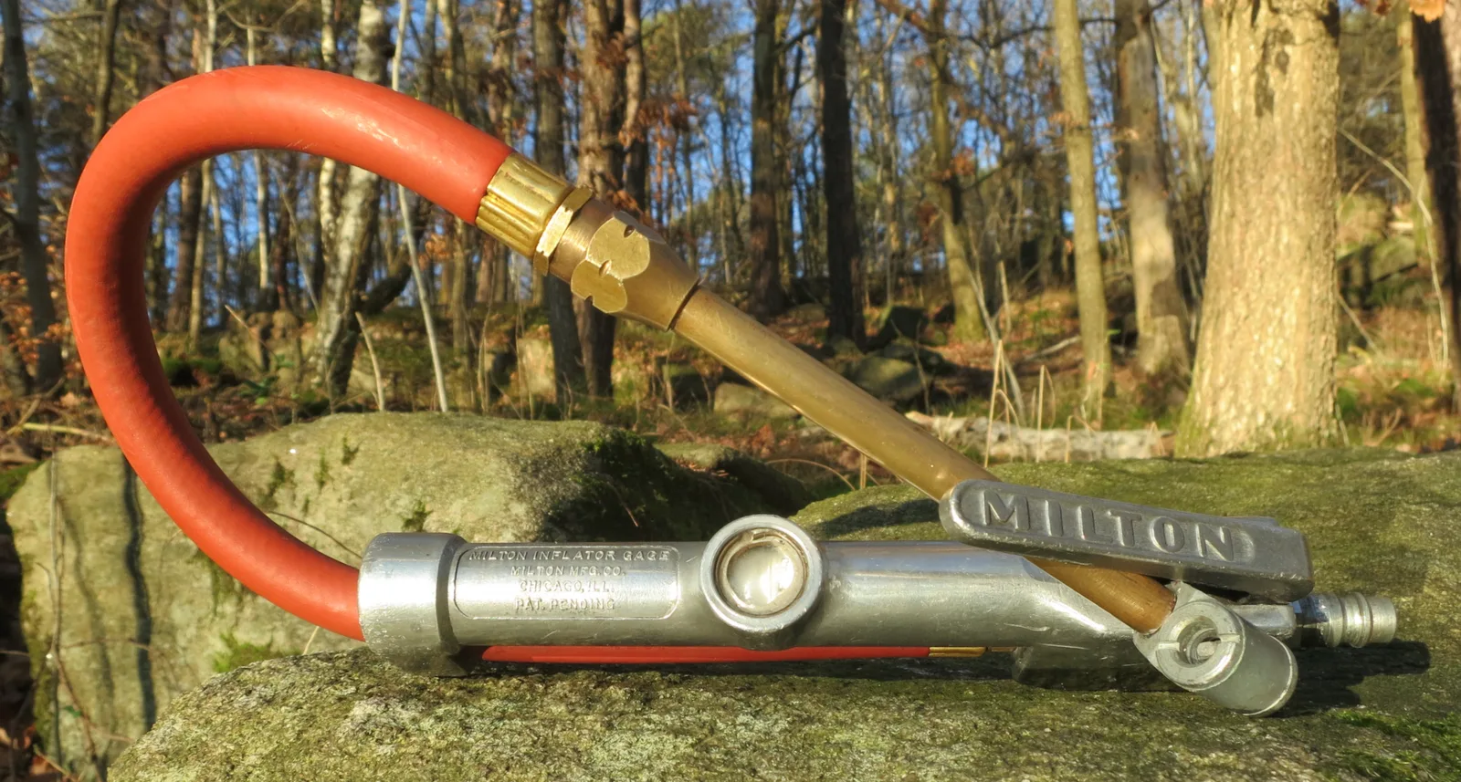 Gonfleur manuel avec manomètre intégré et embout de valve, utilisé pour regonfler les pneus d'une voiture