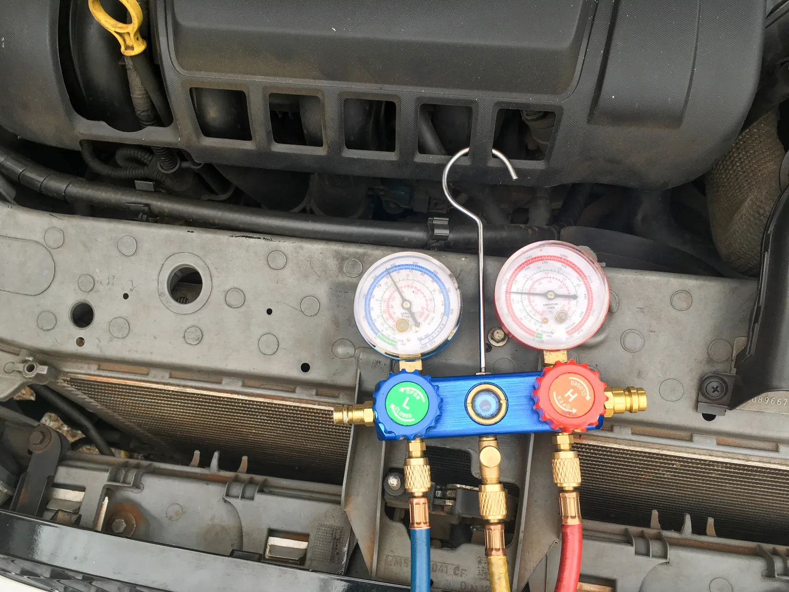 Manomètres haute et basse pression branchés sur le circuit de climatisation d'une voiture