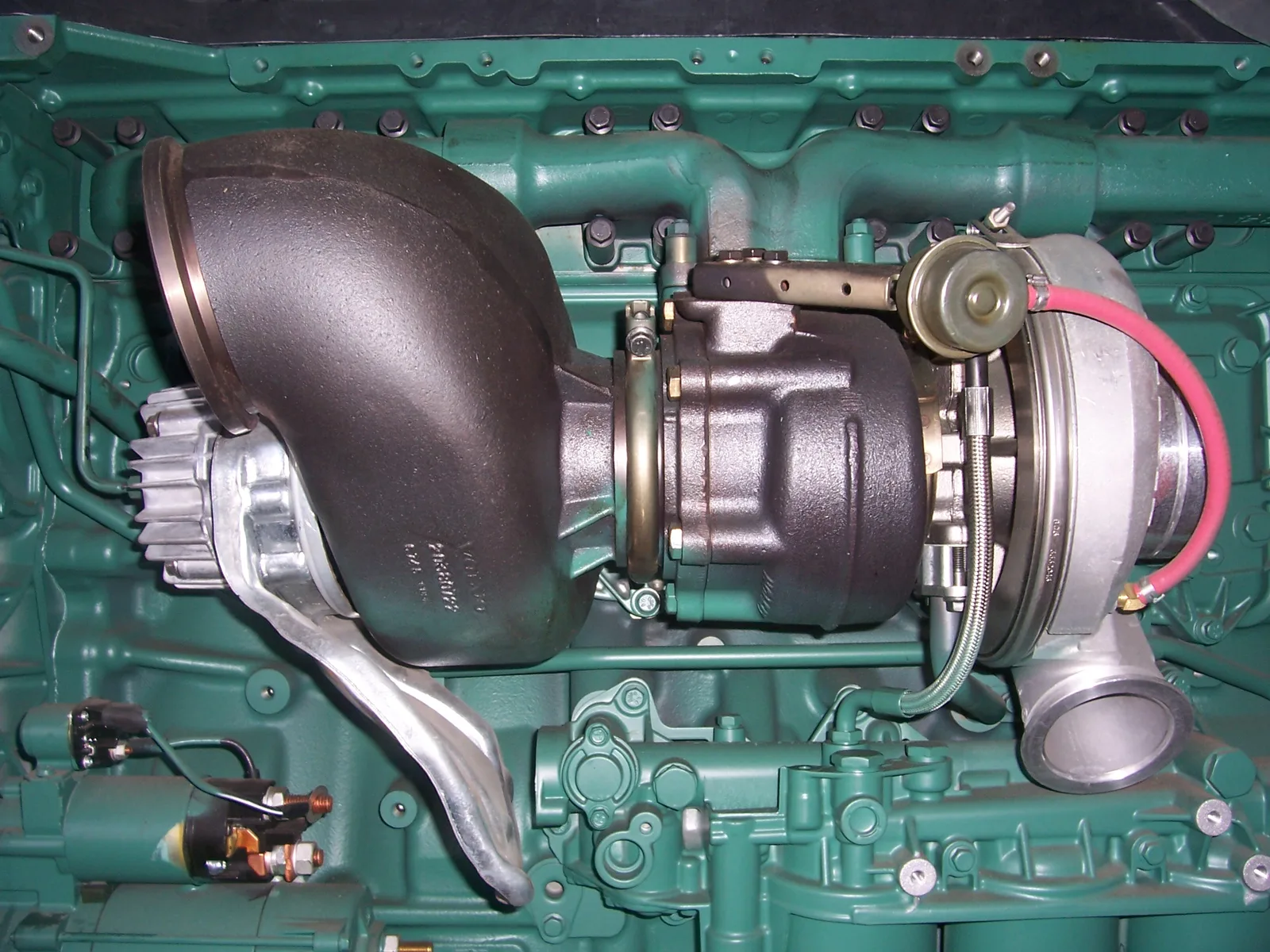 Turbocompresseur monté sur un moteur avec sa conduite de graissage et son actionneur de régulation