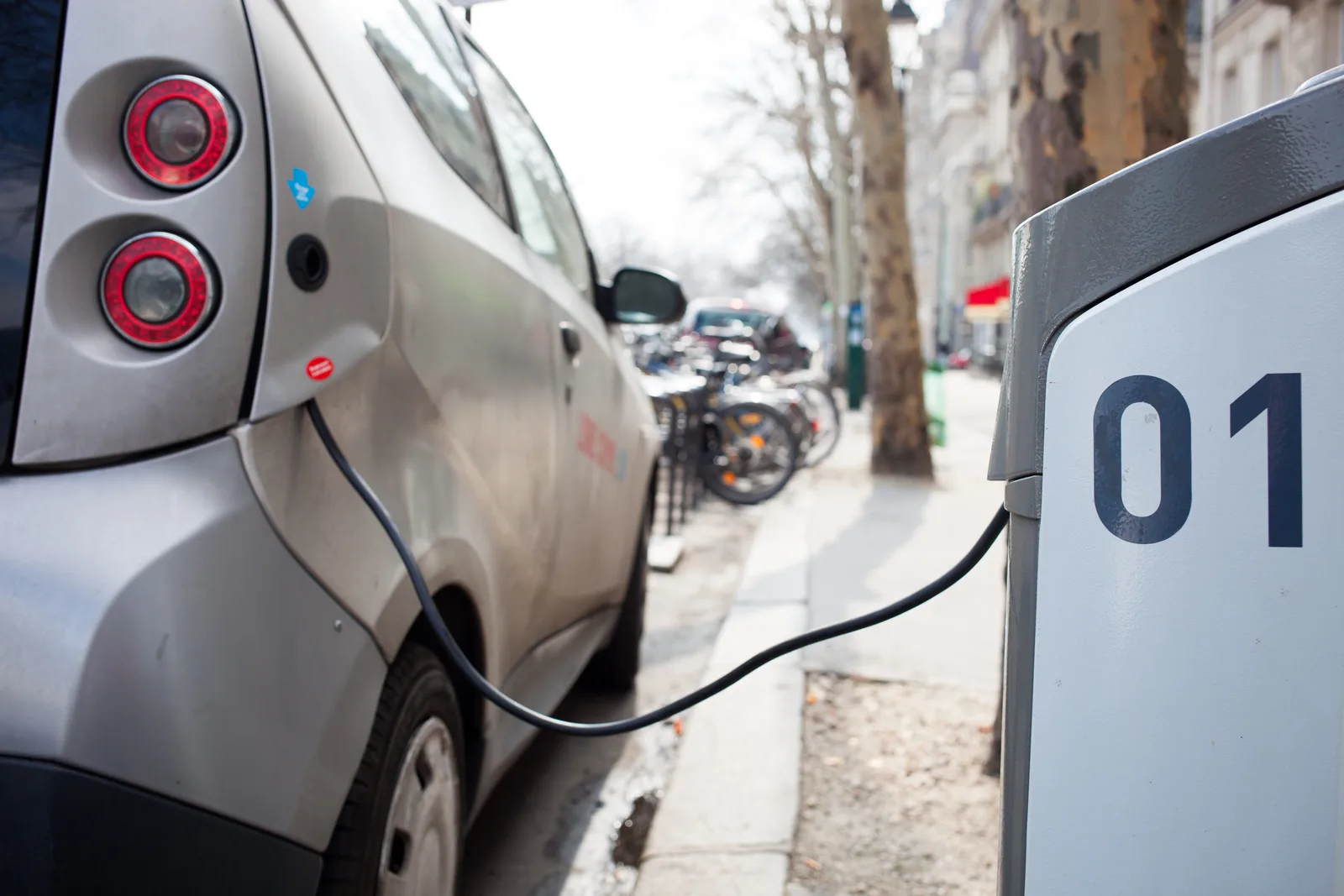 Voiture électrique en recharge sur une borne publique dans une rue de Paris
